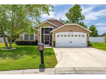 Charming one-story home featuring a well-manicured lawn and an attached two-car garage at 239 King George Dr, Davenport, FL 33837