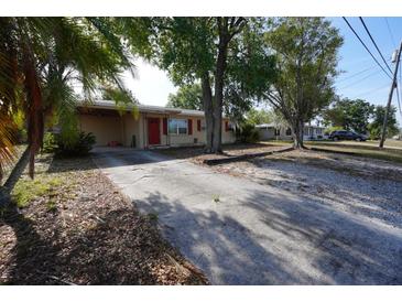Charming single-story home with a driveway, mature trees, and red shutters for added curb appeal at 26 College Dr, Babson Park, FL 33827