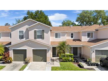 Inviting two-story townhouse with well-manicured landscaping, attached garages, and neutral stucco exterior at 3071 Seaview Castle Dr, Kissimmee, FL 34746