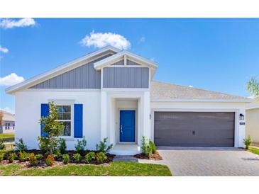 Charming one-story home with blue door, blue shutters, and a two car garage on a sunny day at 4928 Worchester Dr, Kissimmee, FL 34746