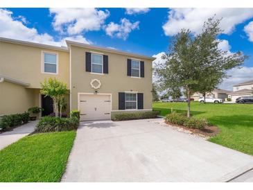 Charming two-story home with a well-maintained lawn, lush landscaping, and a convenient attached garage at 9056 Wildflower Ln, Kissimmee, FL 34747