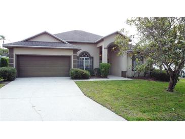 Charming single-story home with a two-car garage and well-manicured lawn at 925 Montana Ave, Davenport, FL 33897