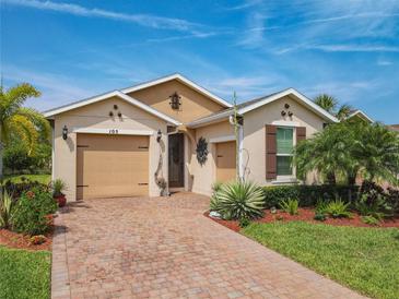 Charming single-Gathering home with a brick driveway, landscaped yard, and attached two-car garage at 105 Palazzo Ln, Kissimmee, FL 34759