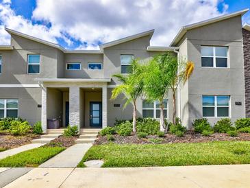 Modern townhouse featuring a landscaped front yard and a contemporary architectural design at 1058 Splash Shot Pl, Davenport, FL 33896