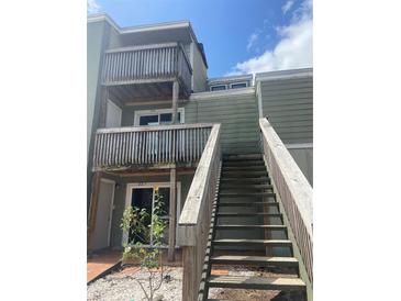 View of a two-story townhome with wooden balconies and staircase leading to the upper units at 228 Scottsdale Sq # 228, Winter Park, FL 32792