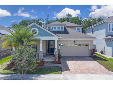 Inviting two-story home with a brick driveway, two-car garage, and well-manicured lawn at 2487 Empress Dr, Kissimmee, FL 34741