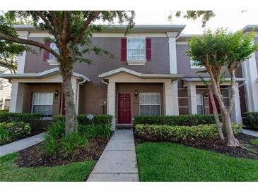 Charming townhome with well-maintained landscaping and a welcoming red front door at 3426 Wilshire Way Rd # 189, Orlando, FL 32829