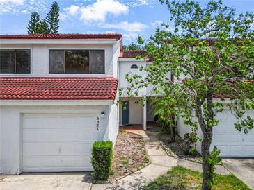 Inviting townhome featuring a two-car garage and a red tile roof, nestled in a charming neighborhood at 5077 Ernst Ct # 3, Orlando, FL 32819