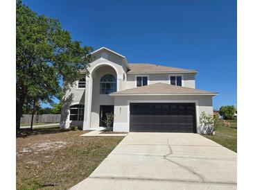 Charming two-story home with a two car garage and a well-manicured lawn at 511 Elbridge Pl, Kissimmee, FL 34758