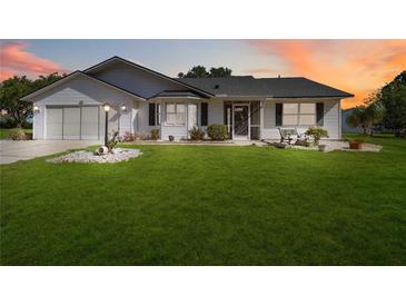 Charming single-story home with a well-manicured lawn and inviting front porch at 5919 Mcenroe Ct, Leesburg, FL 34748