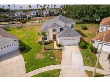 Well-maintained two-story home with manicured lawn, mature landscaping, and a spacious driveway to an attached two-car garage at 8217 Fan Palm Way, Kissimmee, FL 34747