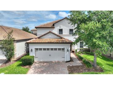 Charming two-story home featuring a red-tiled roof, two-car garage and a well-manicured front yard at 9163 Wedge Dr, Davenport, FL 33896