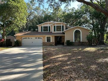 Charming two-story home with a well-manicured lawn, mature trees, and an attached two-car garage at 1835 Harbor Blvd, Kissimmee, FL 34744