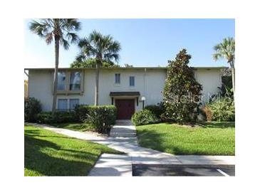 Inviting condo featuring a lush green lawn, mature trees, and a pathway to the front door at 200 Maitland Ave # 80, Altamonte Springs, FL 32701
