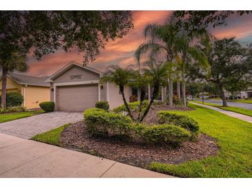 Charming single-story home featuring a well-manicured lawn and tropical landscaping at 247 Bell Tower Xing W, Poinciana, FL 34759