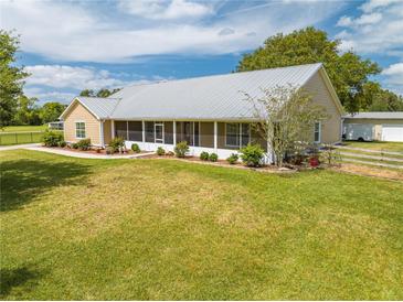 Charming single-story home with a well-manicured lawn, screened front porch, and a durable metal roof at 3048 Cherokee Rd, St Cloud, FL 34772