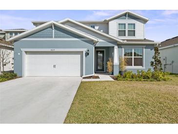 Charming two-story home with a well-manicured lawn, a two car garage and a welcoming front entrance at 6019 Forest Perch Dr, St Cloud, FL 34771