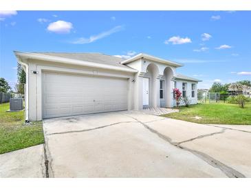 Charming single-Gathering home features a two-car garage, white stucco exterior, and well-maintained landscaping at 650 Mesilla Dr, Kissimmee, FL 34758