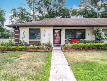 Charming home with a landscaped yard, flower beds, and beautiful walkway at 12539 Orangewood Ct, Tavares, FL 32778