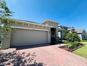 Charming home featuring a two-car garage, a brick driveway, and well-maintained landscaping at 1321 Yorkdale Rd, Davenport, FL 33837