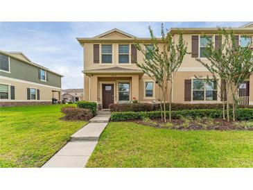 Inviting two-story townhome with well-maintained lawn and charming front facade at 1818 Katz Crossing Dr, Kissimmee, FL 34744