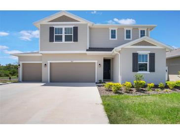 Beautiful two-story home with a three car garage, manicured lawn, and a well-kept garden at 2821 Cathy Blvd, Winter Haven, FL 33880