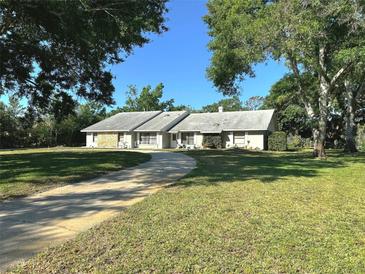 Charming single-story home featuring a well-manicured lawn, a stone facade and a paved driveway at 3328 Wax Berry Ct, Windermere, FL 34786
