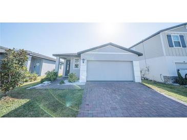 Charming single-Gathering home with a brick driveway, lush lawn, and well-maintained landscaping at 3451 Monaco Ln, Davenport, FL 33897