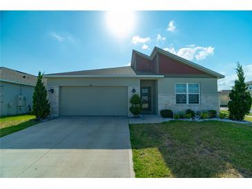 Inviting single-story home boasts stone accents, well-maintained landscaping, and an attached two-car garage at 400 Chayne Pl, St Cloud, FL 34771