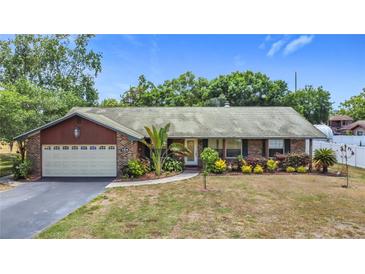Charming single-story brick home with a two-car garage and beautifully landscaped front yard at 724 Knob Hill Cir, Kissimmee, FL 34744