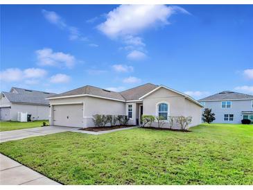 Charming single-story home with manicured lawn and beautiful landscaping at 724 Lake Cummings Blvd, Lake Alfred, FL 33850