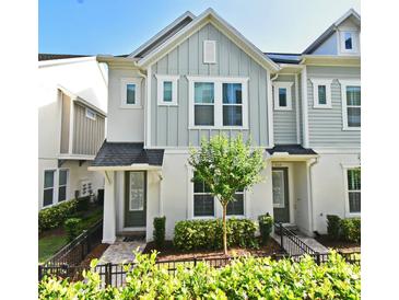 Charming two-story townhome with gray siding, manicured landscaping, and a welcoming front entrance at 932 Wild Date Ln, Lake Mary, FL 32746