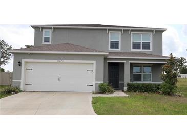 Charming two-story home featuring a two-car garage, well-maintained lawn, and neutral exterior paint at 11273 Amber Ridge Dr, Zellwood, FL 32798