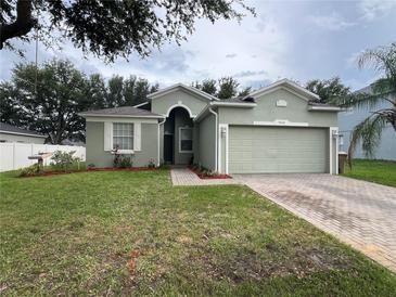 Inviting single-story home with a two car garage and well-maintained lawn with mulch at 15408 Groose Point Ln, Clermont, FL 34714