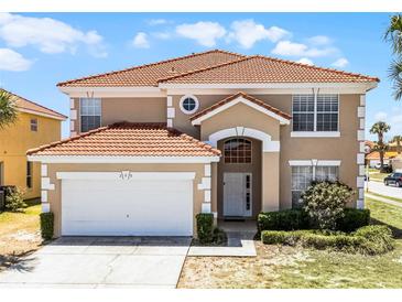 Two-story home featuring a red tile roof, attached garage, and well-maintained landscaping at 209 Rosso Dr, Davenport, FL 33837