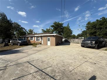 The house has a concrete driveway, neutral paint color and white trim around the windows at 311 Congress Ave, Auburndale, FL 33823
