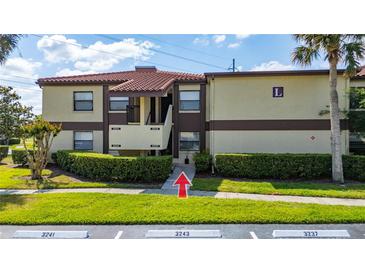 Condo building with well-maintained landscaping, tile roof, and neatly trimmed bushes at 3235 Candle Ridge Dr # 102, Orlando, FL 32822