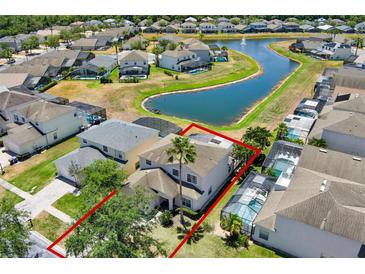 Beautiful aerial view of the property, backing onto a serene pond with neighboring homes and lush landscaping at 4739 Cumbrian Lakes Dr, Kissimmee, FL 34746