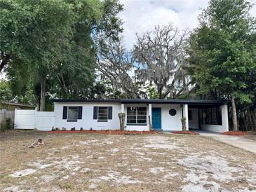 Charming single-story home featuring a blue front door and a covered carport at 906 San Domingo Rd, Orlando, FL 32808