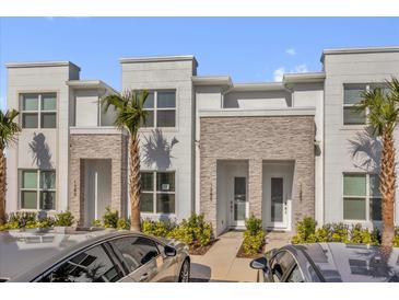 Charming townhome featuring a stone facade, tidy landscaping, and a welcoming entrance at 1385 Peaceful Nature Way, Clermont, FL 34714