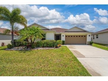 Charming single-story home with a lush, green lawn, mature landscaping, and a two-car garage at 1532 Angler Ave, Kissimmee, FL 34746