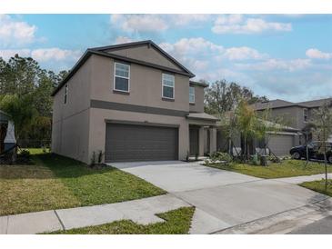 Charming two-story home with a two-car garage and well-maintained lawn and fresh landscaping at 2189 Teneroc Trl, Lakeland, FL 33801