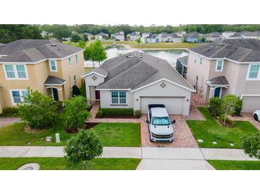 Charming single-Gathering home features manicured lawn and a brick driveway, set against a serene pond backdrop at 3298 Stratton Cir, Kissimmee, FL 34744