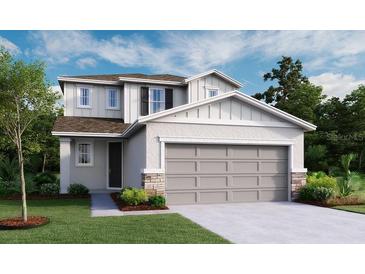 Two story home with a two car garage, neutral color palette, stone accents, and manicured lawn at 737 Lake Dell Rd, Dundee, FL 33838