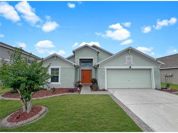 Charming single-Gathering home with well-manicured lawn, lush landscaping, and an attached two-car garage at 8439 Adele Rd, Lakeland, FL 33810