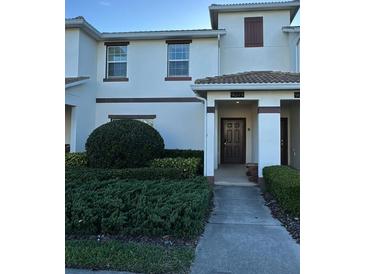 Inviting townhome with a well-maintained lawn and neatly trimmed shrubs at 9079 Dogleg Dr, Davenport, FL 33896