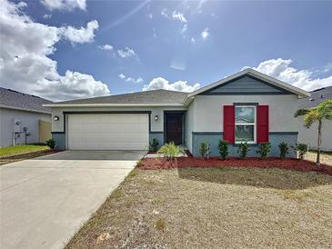 Charming single-story home with a two-car garage, red mulch, and well-maintained landscaping at 119 Summerlin Loop, Haines City, FL 33844