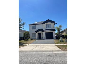 Charming two-story home with a well-maintained front yard and a paved driveway leading to an attached garage at 1211 Carey Glen Cir, Orlando, FL 32824