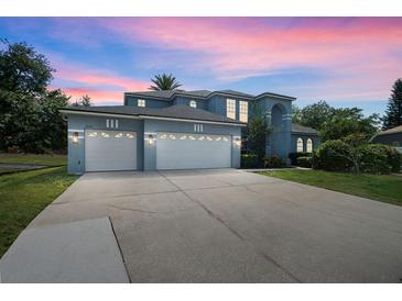 Elegant two-story home featuring a three-car garage and a long driveway at 13044 Lakeshore Grove Dr, Winter Garden, FL 34787