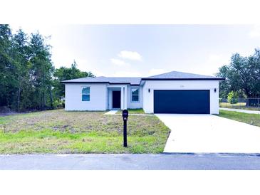 Charming single story home with a large two car garage and neatly manicured lawn at 318 Cocoa Ct, Kissimmee, FL 34758